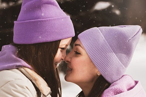 Mother and Daughter in Purple Beanie Hat Nose to Nose with Each Other
