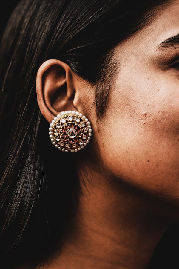 Person Wearing Silver and Gold Stud Earring