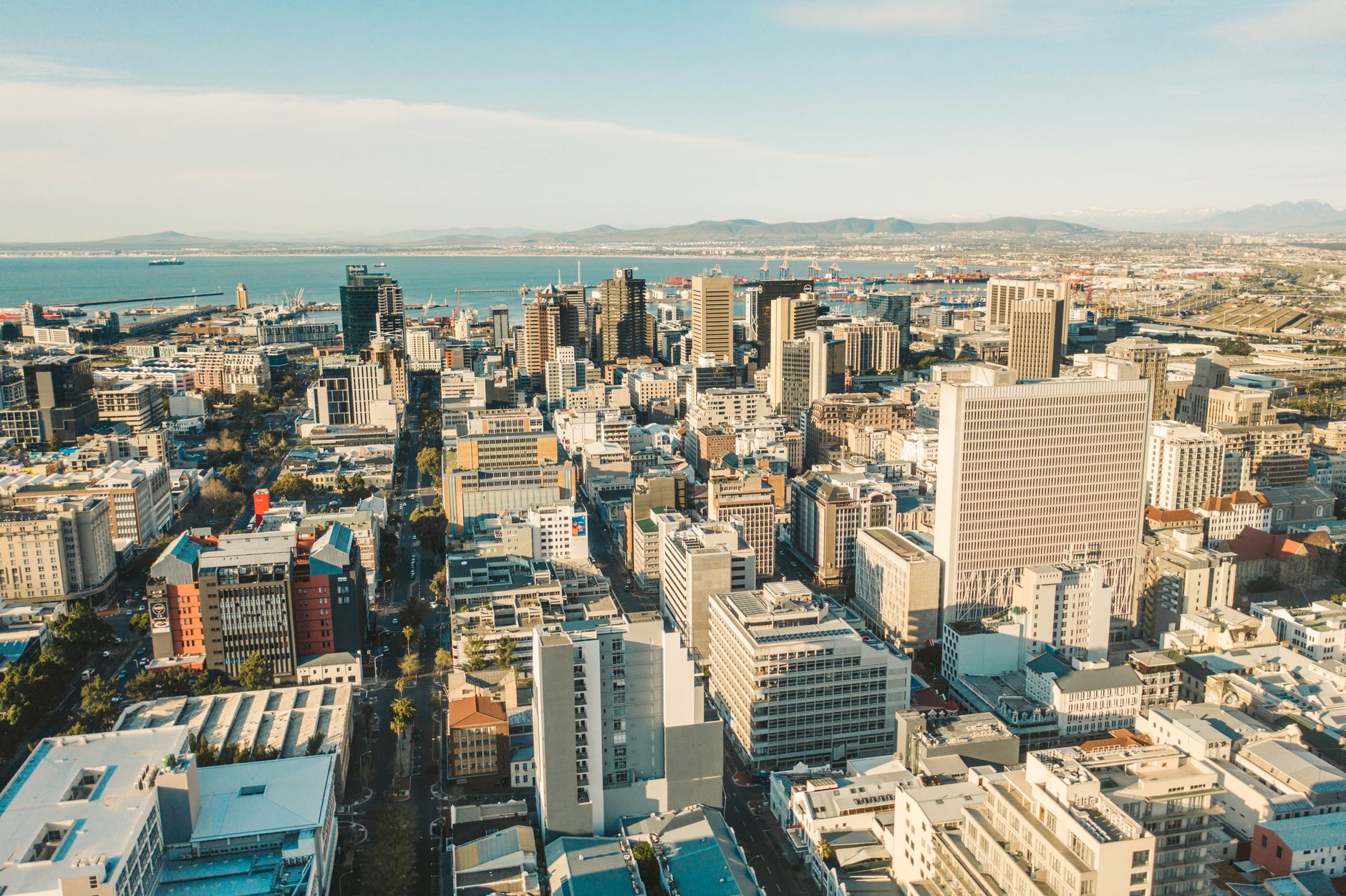 Aerial photograph showcasing a bustling city skyline with modern skyscrapers by the sea.
