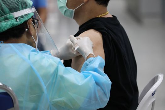 A medical professional gives a vaccine injection to a patient.