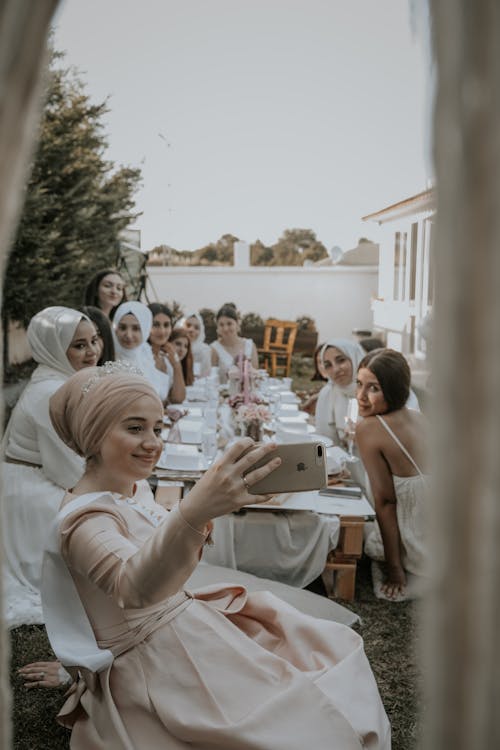 Free Woman Wearing Hijab Taking Selfie with Friends Stock Photo