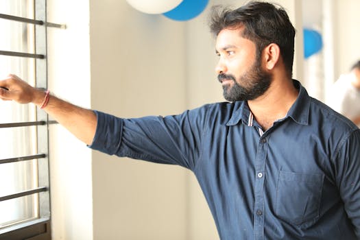 办公室里，一名穿着休闲装的男子凝视窗外，显得很体贴