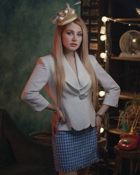 Stylish woman posing indoors in Tehran with a blue skirt and white blouse.