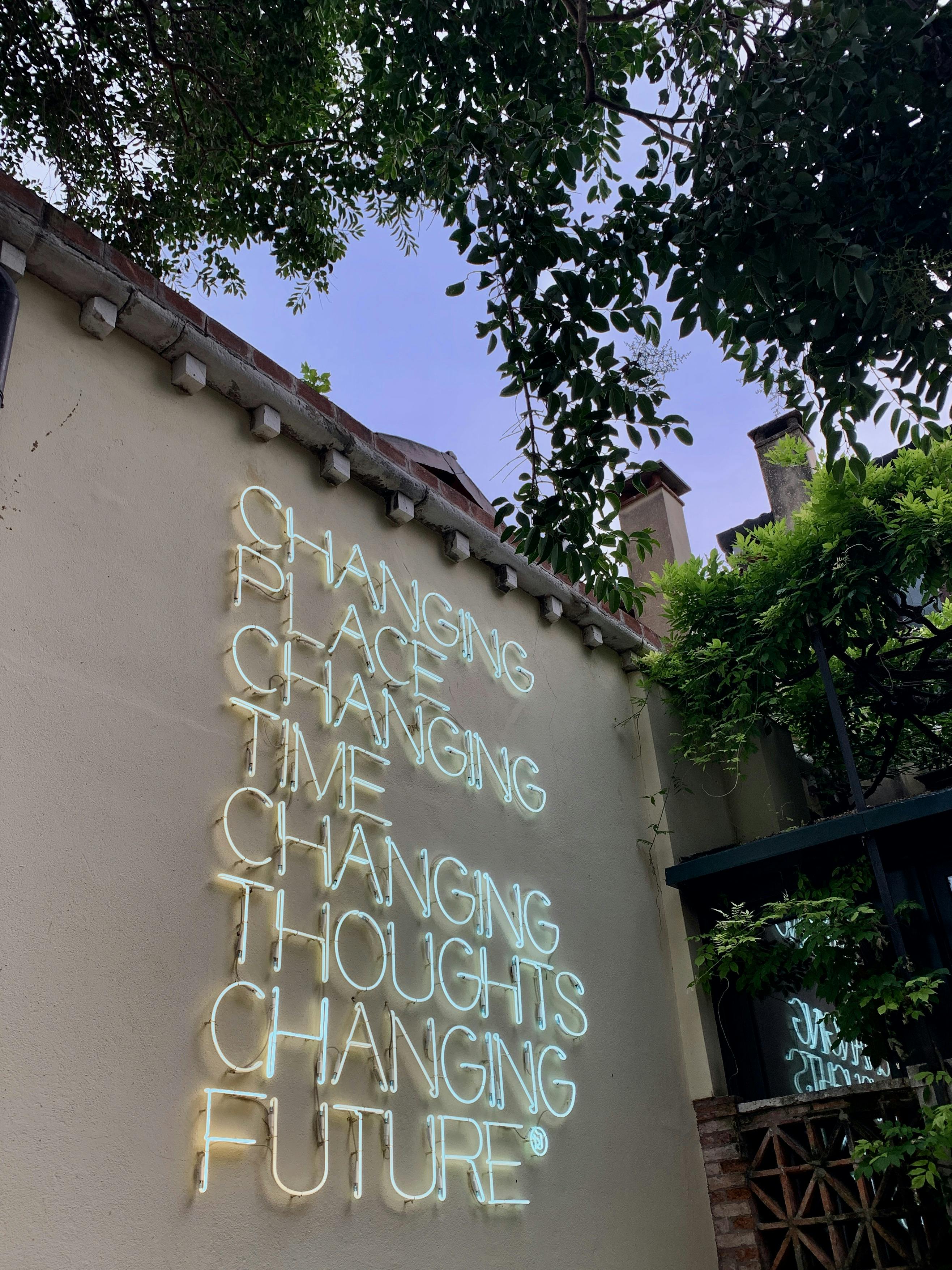 motivational quote in neon sign on a building facade