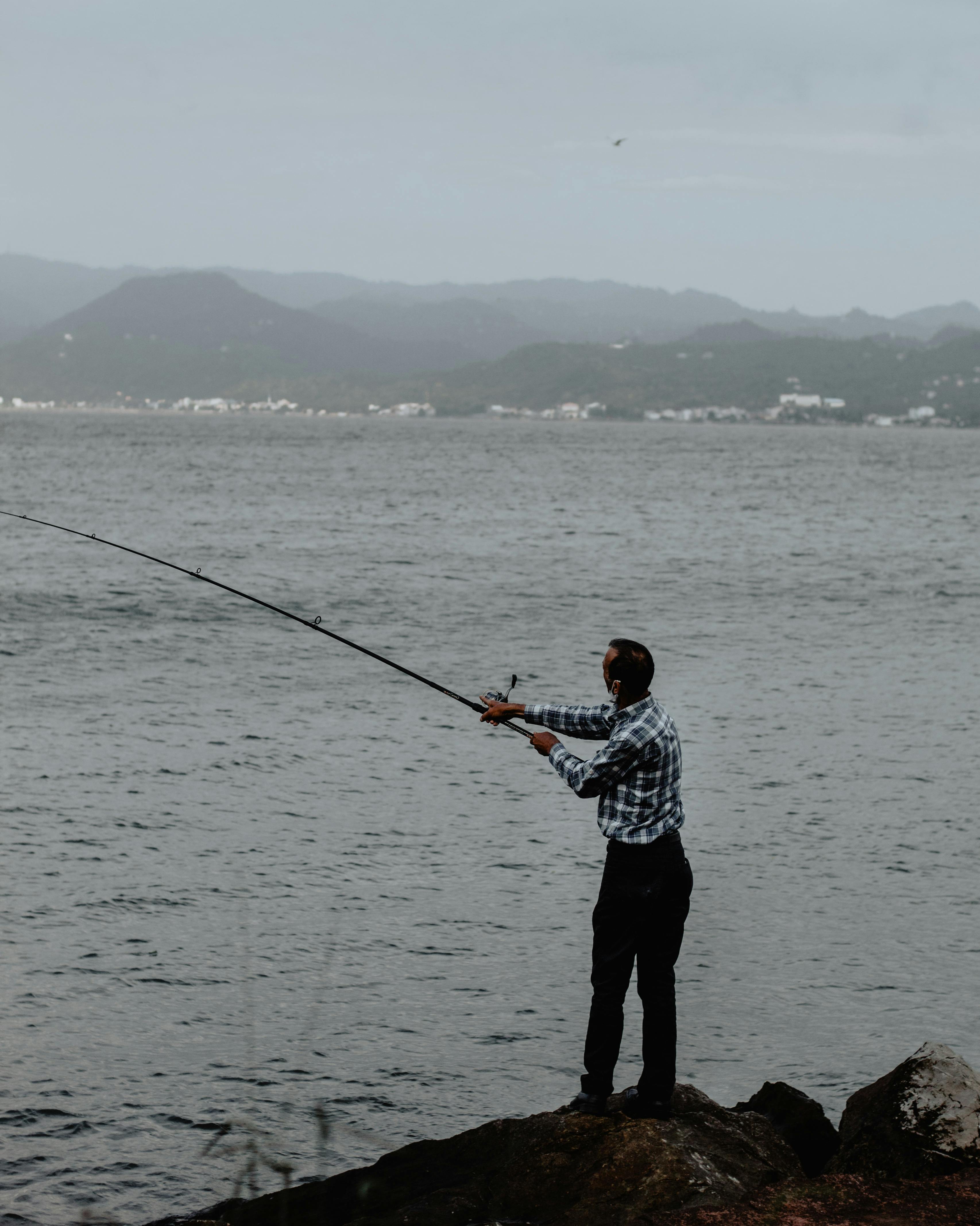 Anonymous fishermen casting fishing rod · Free Stock Photo