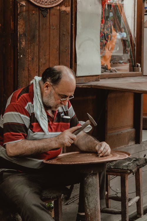 Man in Red and White Striped Polo Shirt Holding Knife