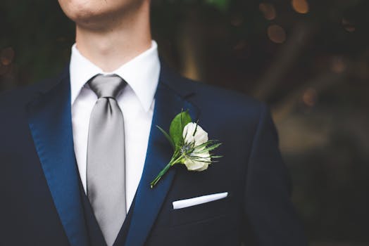 Man in a blue suit with a flower boutonniere and tie, perfect for formal events.