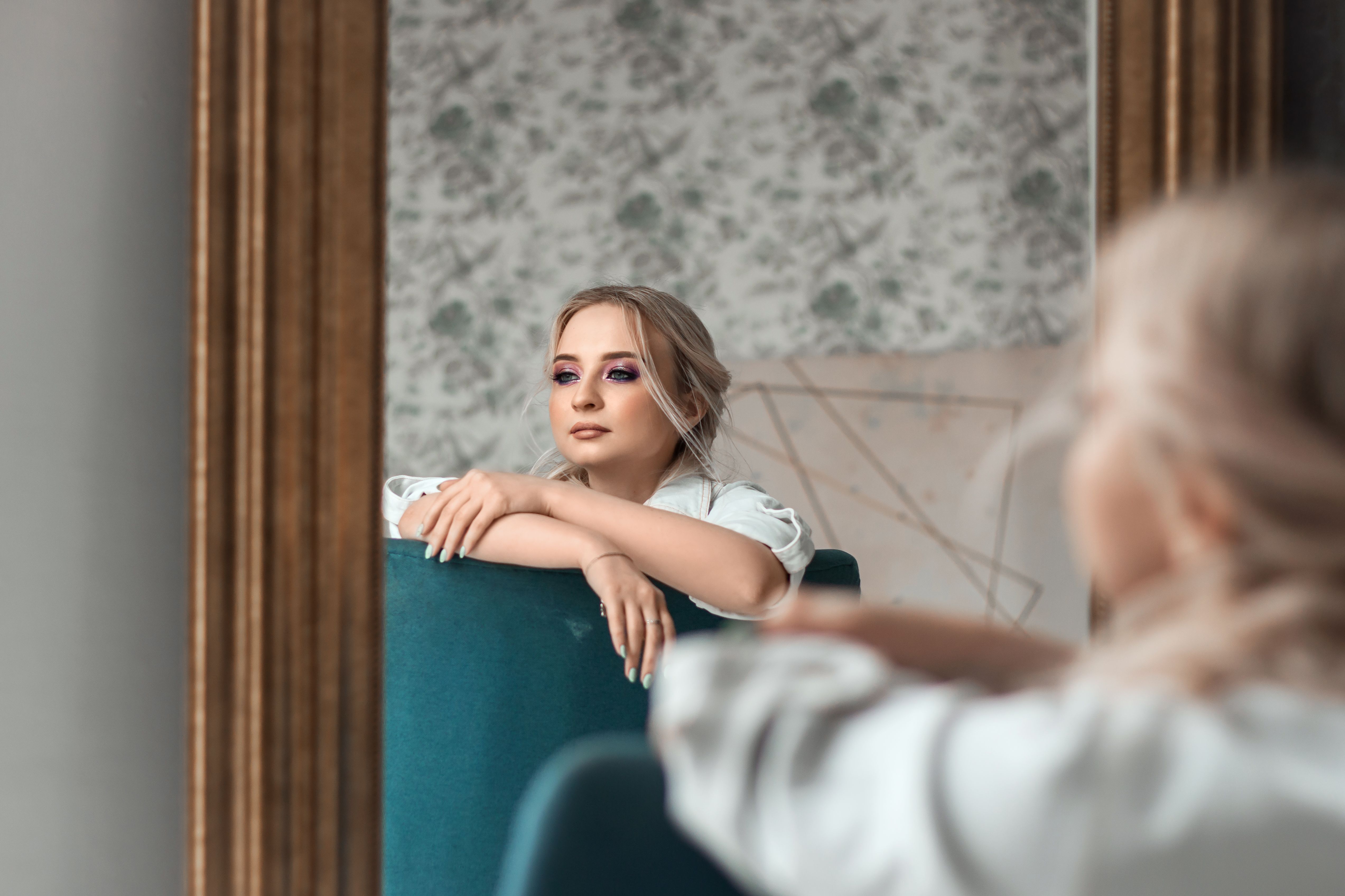 Frau betrachtet ihr Gesicht nach einer Microneedling Erfahrung im Spiegel.