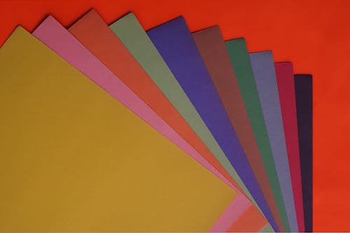 Variety of Colored Papers on Red Surface
