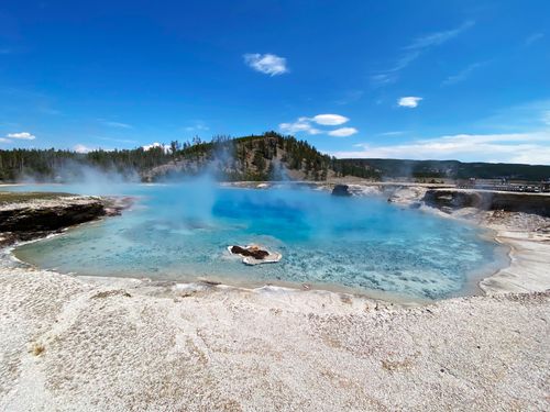 Free Captivating blue geyser pool in Yellowstone with steam under a clear blue sky. Stock Photo