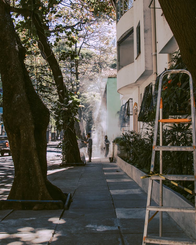 People Cleaning Outside An Apartment Building