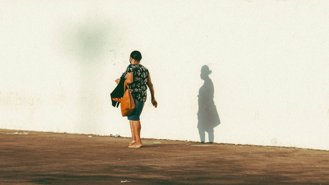Near Shadow Photo of a Woman Walking Near Her Shadow on a Wall · Free Stock Photo