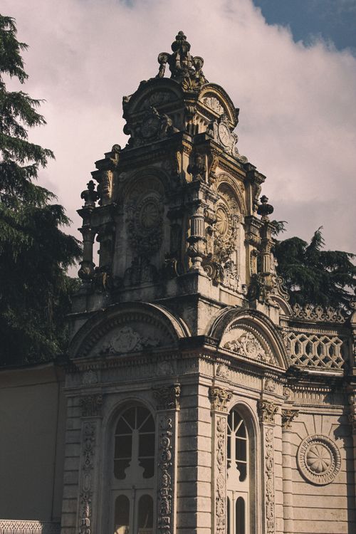 Free A captivating view of an ornate Gothic Revival architectural tower surrounded by greenery. Stock Photo