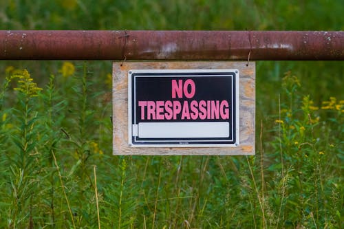 Free No Trespassing Sign Hanging On An Iron Pipe Stock Photo