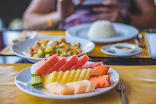 Round Ceramic Plate Filled With Sliced Watermelon, Pineapple, and Carrots