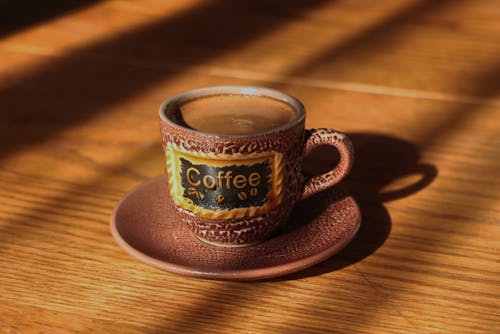 Ceramic Cup of Coffee with Saucer on a 
Wooden Table top