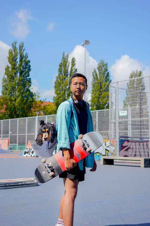 Man in Blue Long Sleeve Shirt Holding a Skateboard