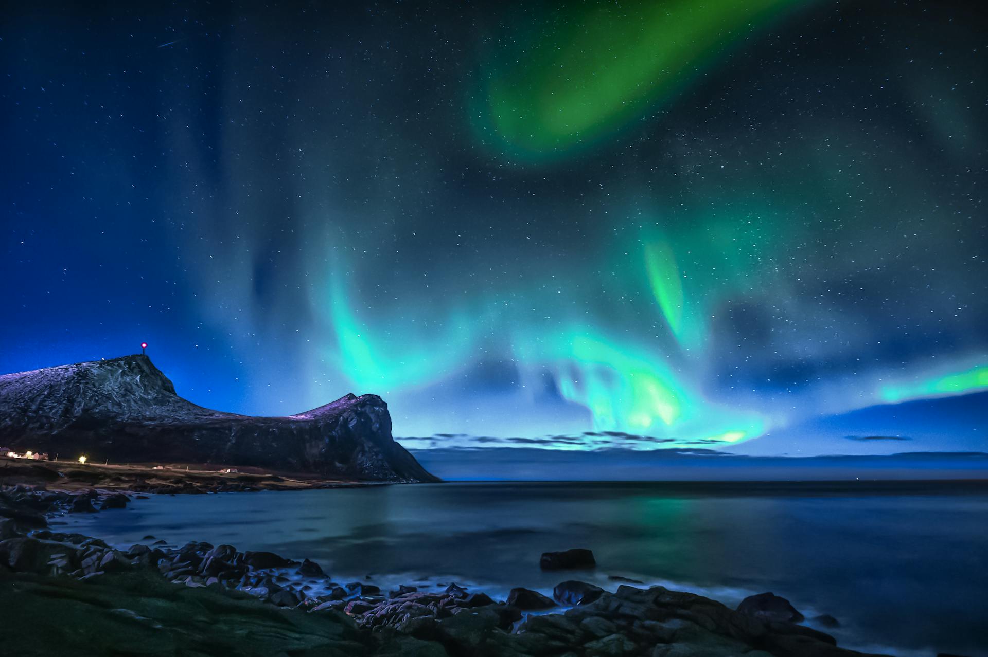 Green Aurora Lights over Rocky Shore during Night Time