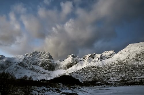 Snow Covered Mountains Under Dark Clouds