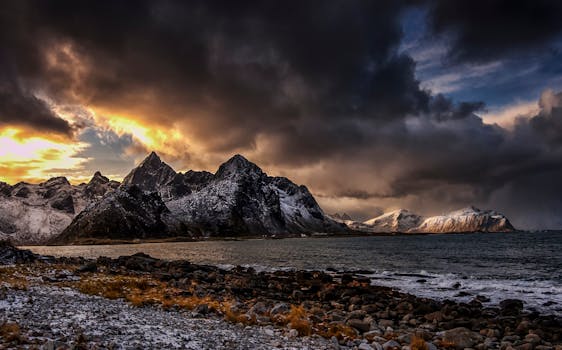 Dramatic Nordic mountains and coastline under a vibrant sunset sky.