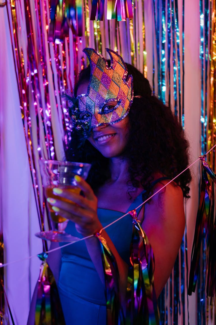 Photograph Of A Woman With A Mask Holding A Drink