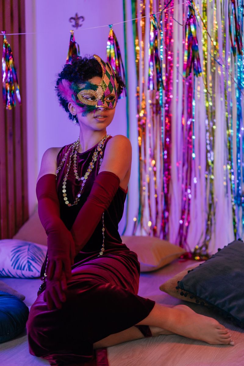 Guest in velvet dress and masquerade mask at a festive party with rich decor