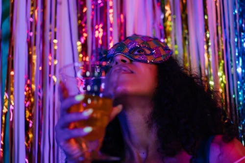 Low-Angle Shot of a Woman with a Mask Holding a Drink