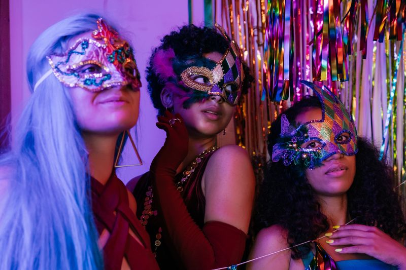 Guests in masquerade masks celebrating together at a vibrant costume party