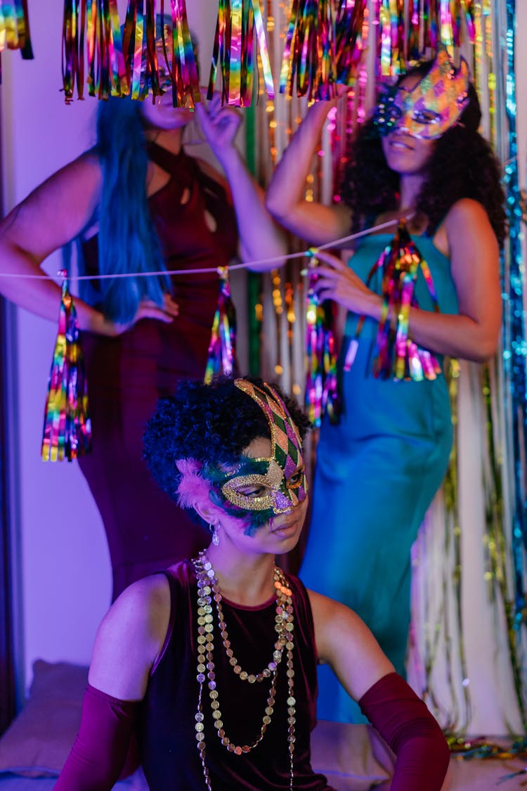 Women Wearing Masks And Dresses At A Party