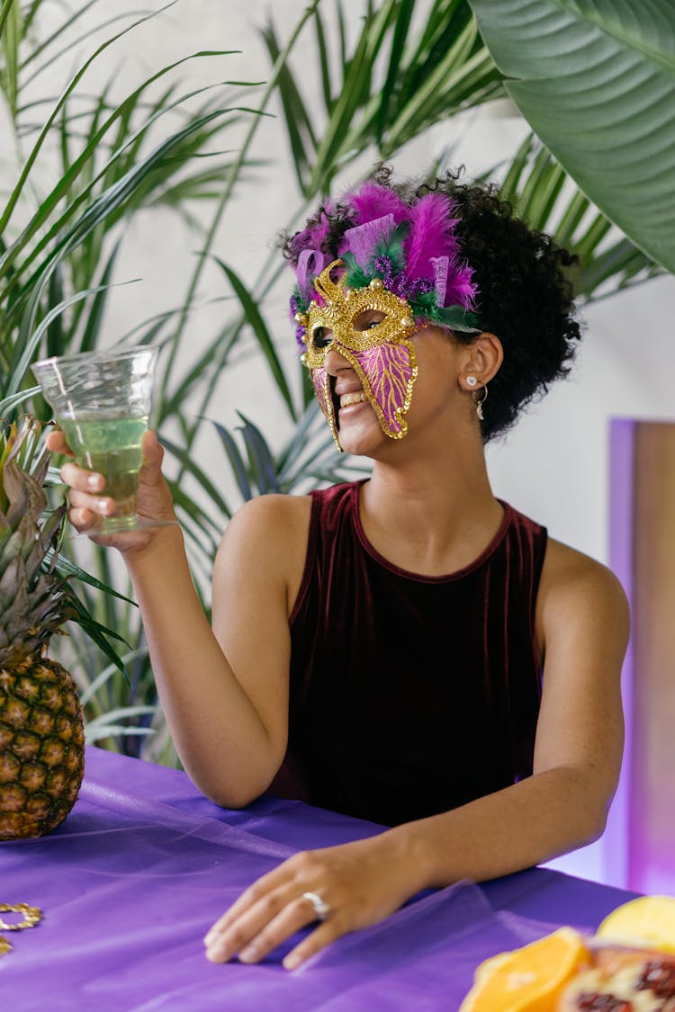 Woman In A Carnival Mask Drinking Champagne