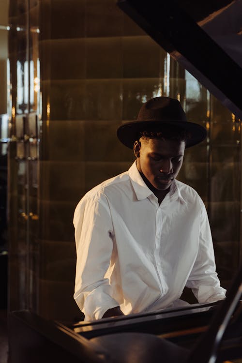 Photo of a Man in a White Dress Shirt Playing the Piano