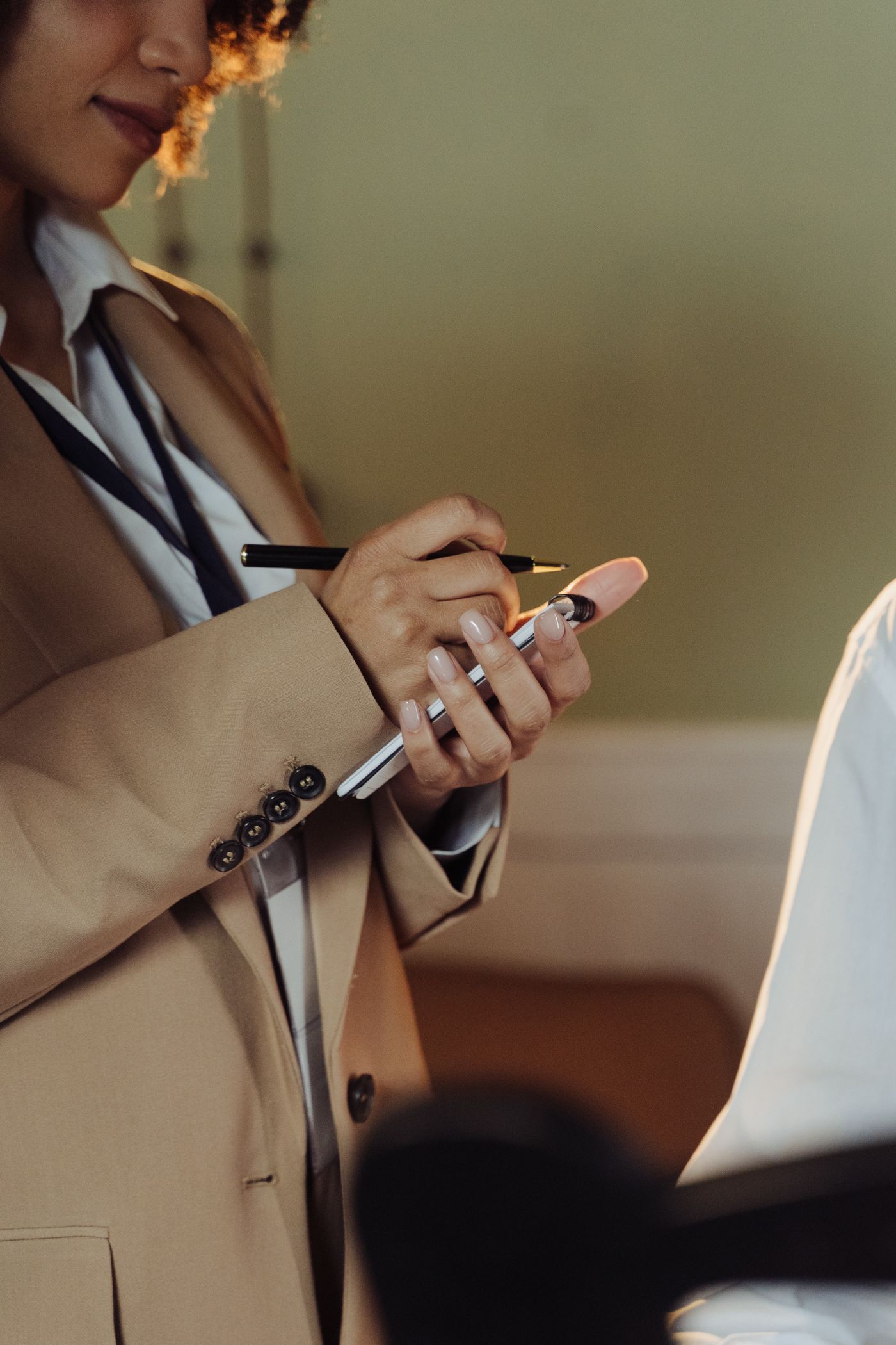 Reporter taking notes with a press badge