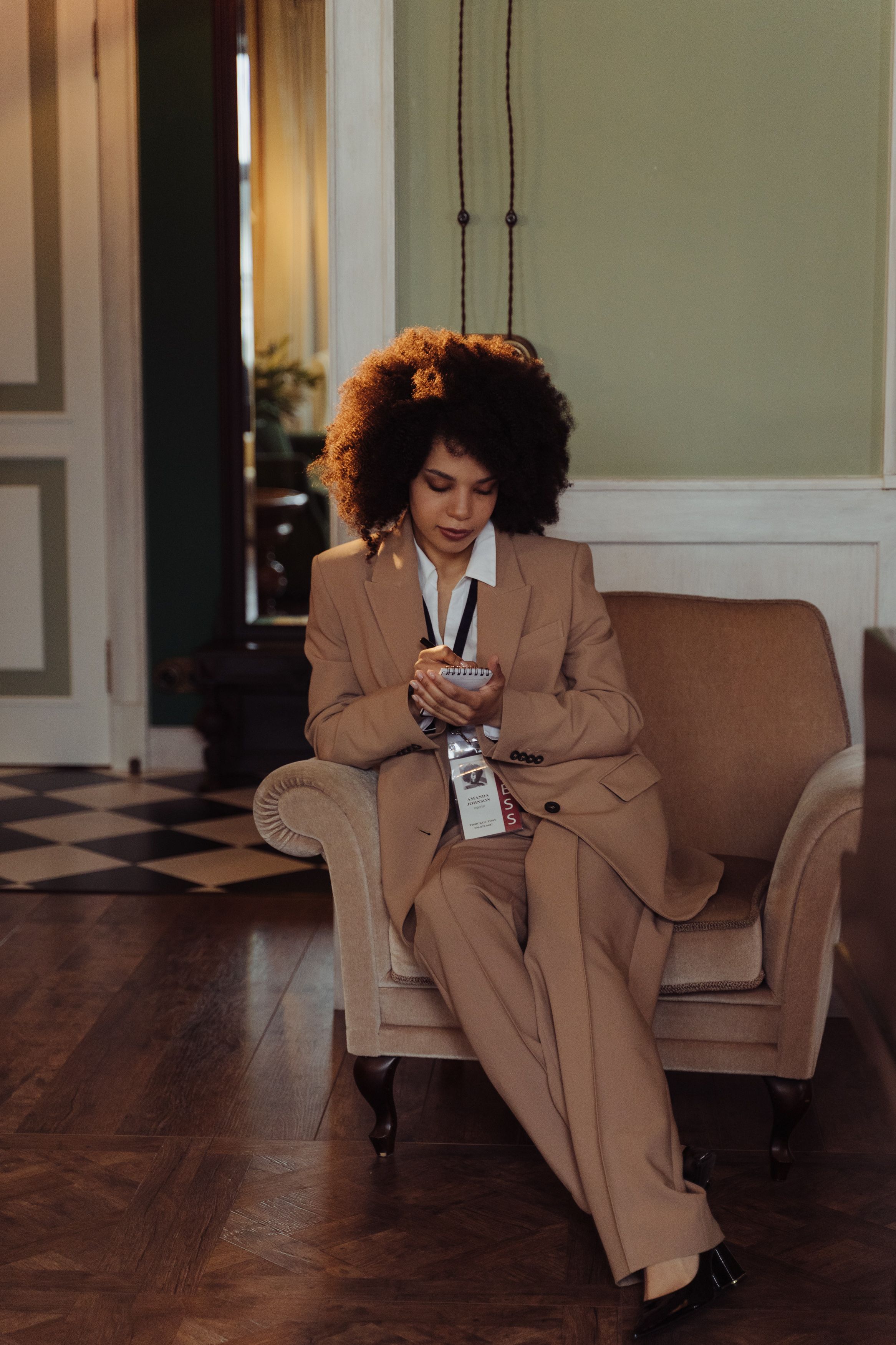 Woman in Brown Blazer Sitting on Brown Sofa Chair · Free Stock Photo