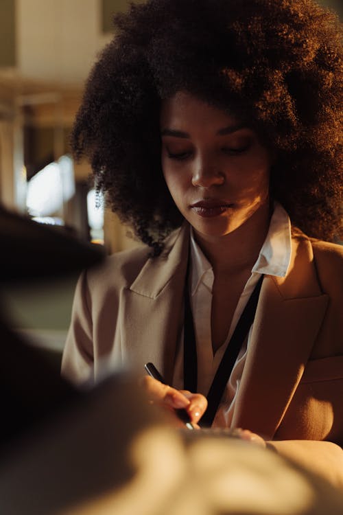 Free Portrait of a Woman with Curly Hair Wearing a Collared Shirt Stock Photo