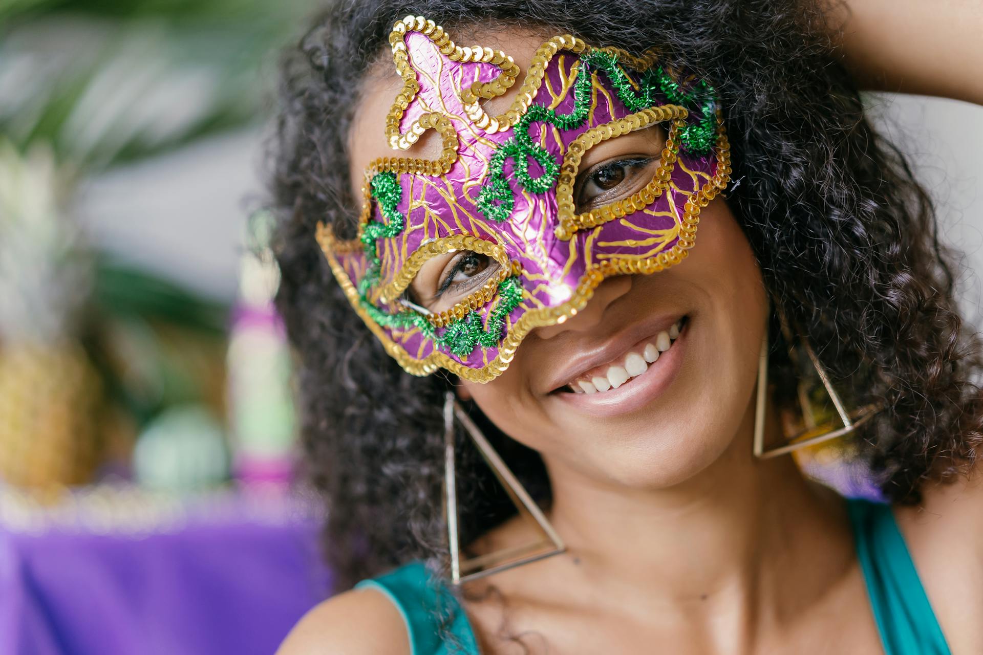 A captivating image of a woman wearing a colorful masquerade mask, smiling joyfully at a carnival event.