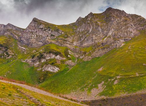 Free Majestic mountain peaks with lush greenery under an overcast sky. Stock Photo