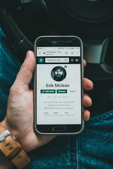 A smartphone displaying a user's social media profile in a person's hand.