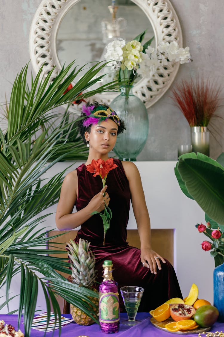 Woman In Maroon Velvet Dress Holding A Flower