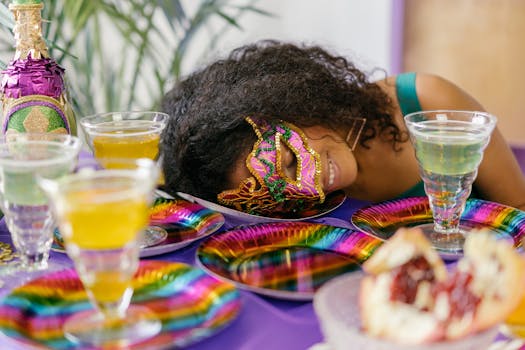 Woman in a festive mask at a vibrant celebration table with colorful drinks.
