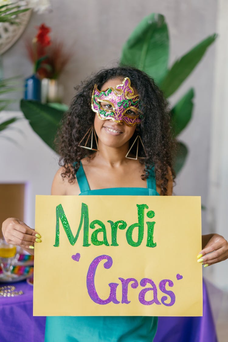 A Woman Wearing A Mask Holding A Poster