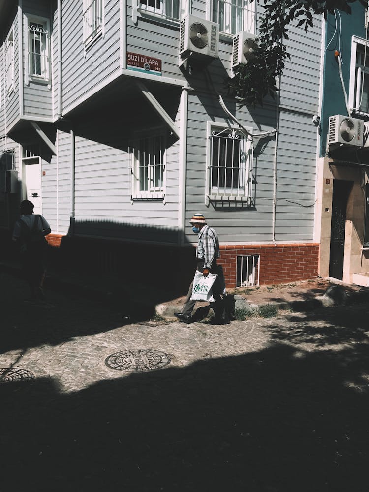 A Man Walking By A House