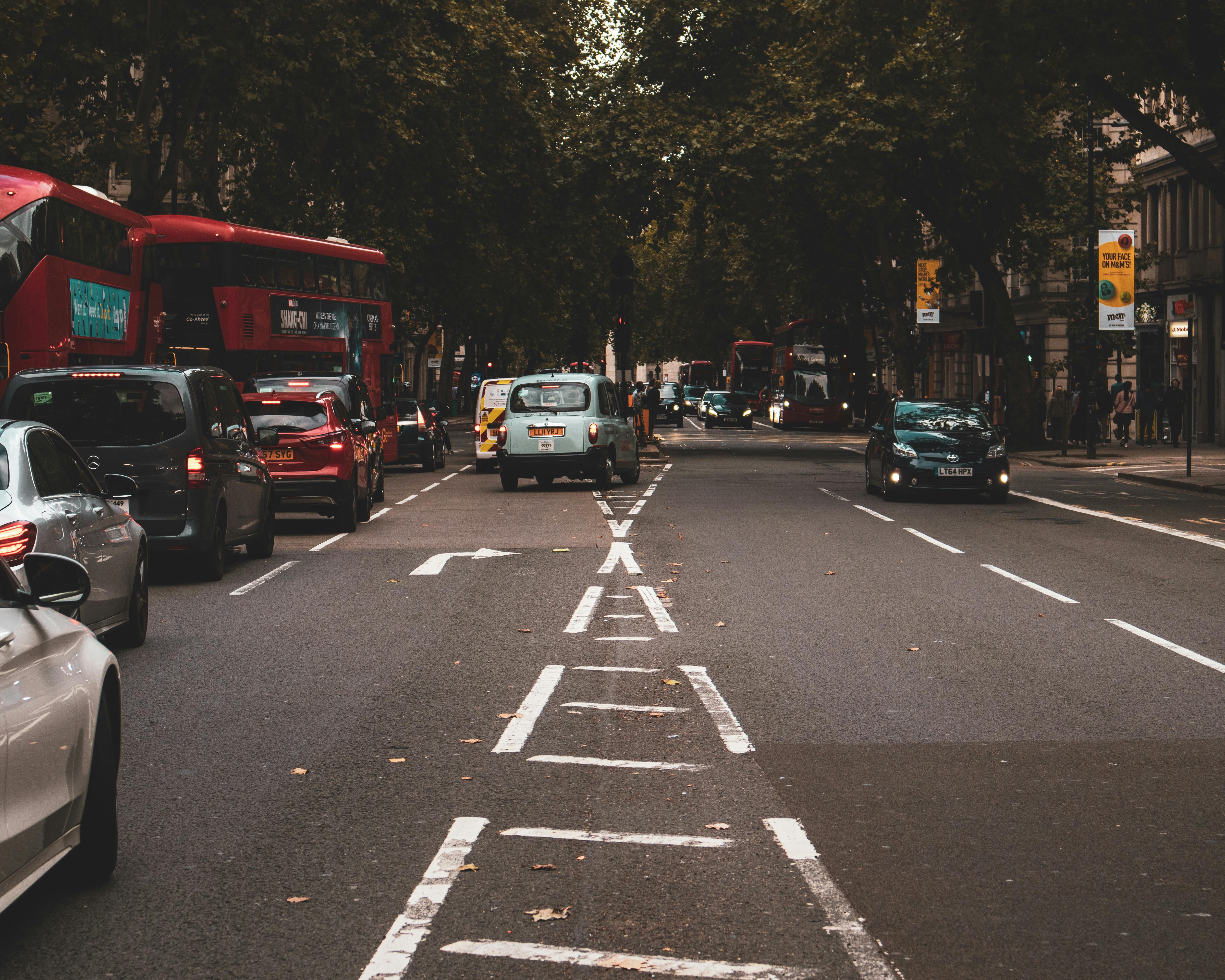 Urban scene capturing traffic on a bustling London street with iconic red buses and cars.