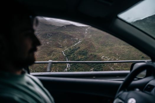 A person driving through the serene and picturesque Swiss mountains, capturing the essence of travel and adventure.