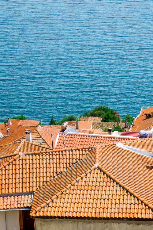 Free Aerial view of Kavala's terracotta rooftops against the blue sea, Greece. Stock Photo