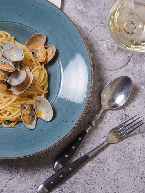 Free A tantalizing top view of spaghetti alle vongole with wine, perfect for food enthusiasts. Stock Photo