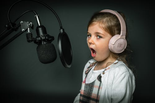 Free A Girl in Front of a Microphone Waring a Headphone Stock Photo