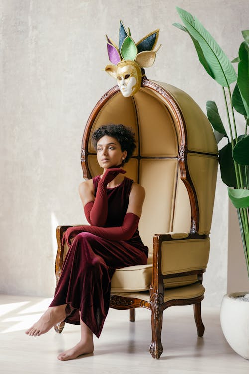 Mask over a Woman Sitting on an Armchair