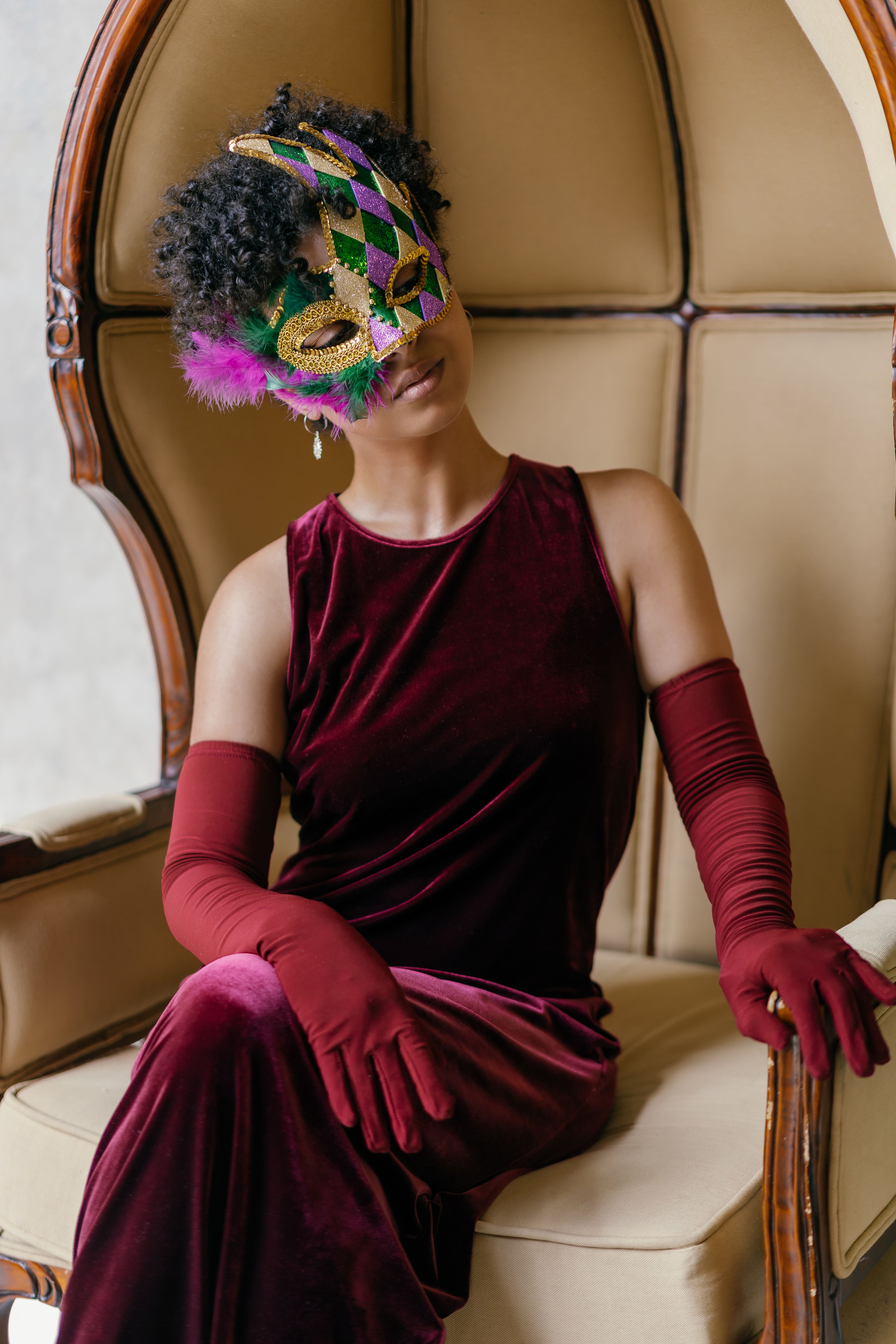 Woman in a garnet velvet cold-shoulder dress with black tights