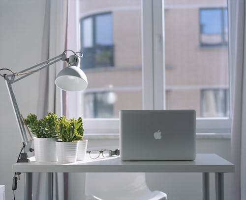 Free Silver Macbook Air and Goose Neck Lamp Stock Photo