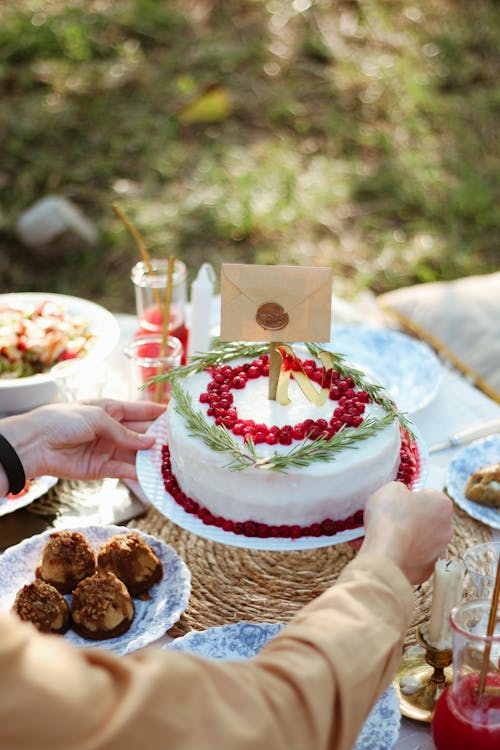 White and Red Cake With Lighted Candles on Table
